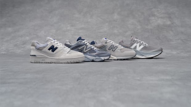 Side view of four grey New Balance sneakers.